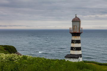 Fototapeta na wymiar Lighthouse on the sea under sky.