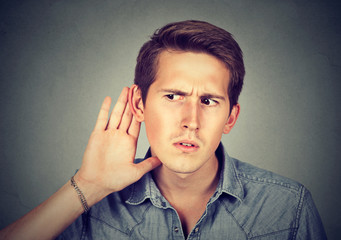 hard of hearing man placing hand on ear listening to gossip