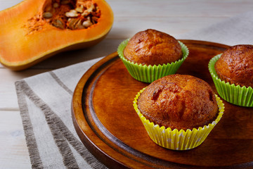 Homemade pumpkin muffins on the cutting board and butternut squa