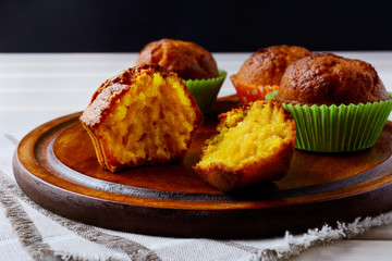 Yellow sweet pumpkin muffins served on the wooden tray