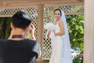 Naklejka premium Bride and photographer take a photo in wedding day