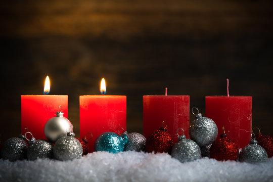 Weihnachtsschmuck und 4 Kerzen von denen zwei symbolisch für den 2. Advent leuchten