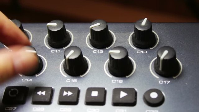 female hand tunes midi synthesizer keyboard
