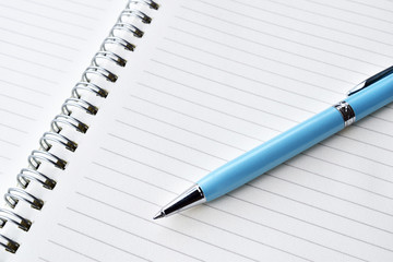 Pen over notebook blank white paper