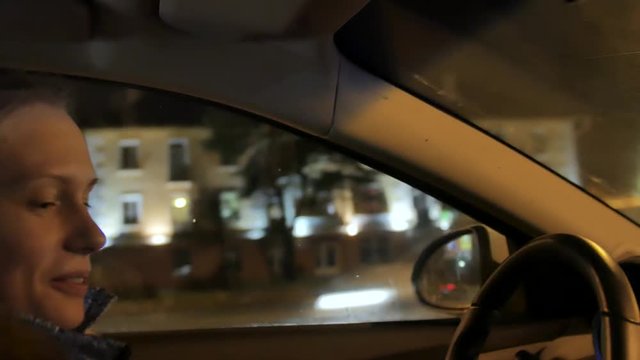 one white blond attractive young woman dring a car at night
