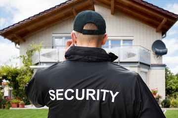 Obraz premium Male Security Guard Standing Outside The House