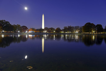 Washington Monument at night with full moon and reflection in pond, Washington DC, USA