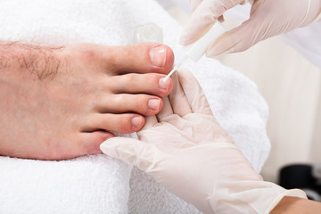 Beautician Applying Nail Oil