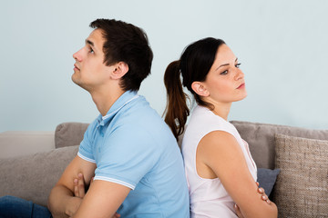 Close Up Of Sad Couple Sitting Back To Back