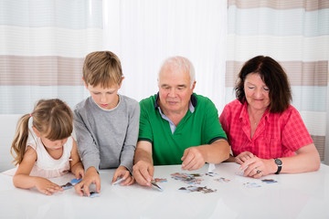 Obraz na płótnie Canvas Multi Generation Family Solving Puzzle Together
