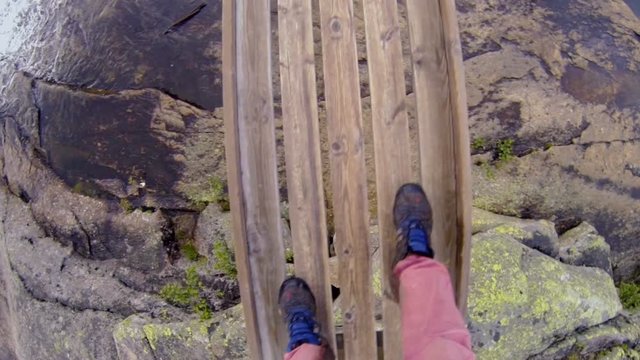 Norway. Man walking on the bridge over the mountain river