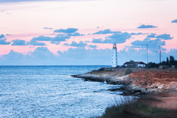 Fototapeta premium Seascape at sunset. Lighthouse on the coast