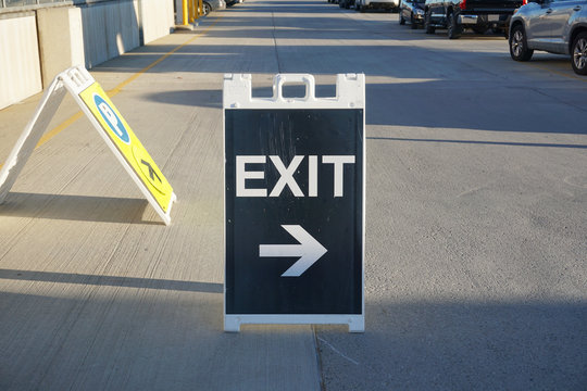 Exit Sign In Parking Lot With Arrow Pointing Direction