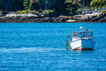 Lobster fishing boat in autumn against deep blue ocean water in coastal Maine, New England