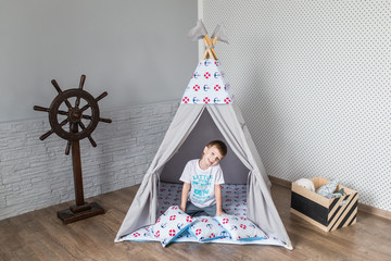 Child playing with a teepee tent