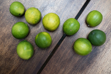 Citricos - limas sobre fondo de madera natural - toma de estudio desde arriba - luz natural