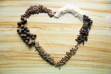 spices on a wooden background with heart shaped place for text