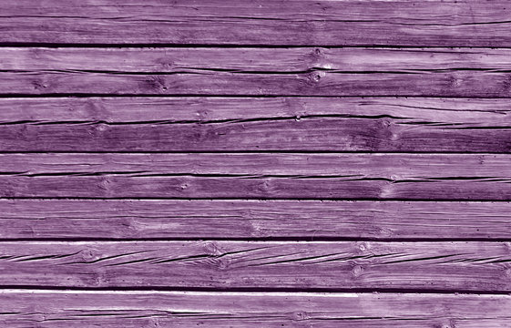 Weathered magenta color log house wall.