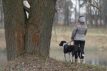 Naklejka na ściany i meble girl with a dog for a walk in the autumn