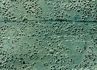 Grungy cyan toned rubber surface with bubbles and scratches.