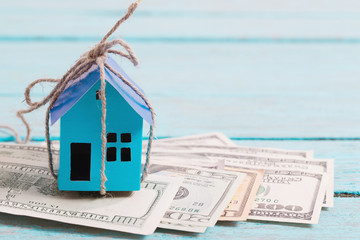 House from the paper and money on wooden background