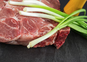 Piece of pork meat on a black stone table