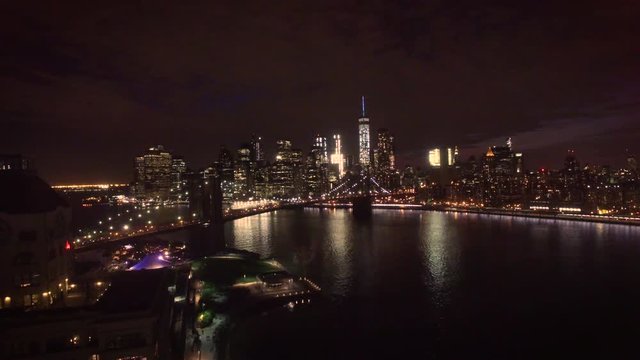 night flying backwards view of Manhattan over bridge
