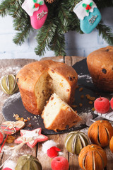 Christmas cake panettone surrounded by holiday decoration close-up. vertical