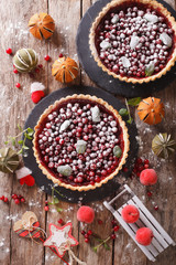 Delicious Christmas cranberry tart and festive decoration close-up. Vertical top view