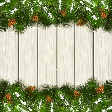Christmas fir tree branches with snow on white wooden background