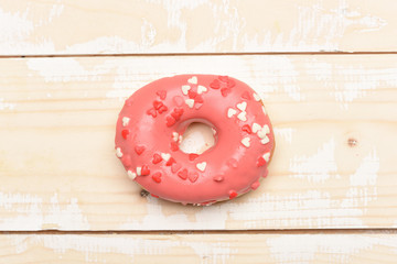 Fototapeta na wymiar Pink glazed donut on vintage background