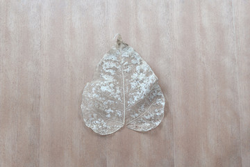 Naklejka premium Dry leave on wooden table
