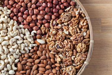 Different nuts in old wooden dish