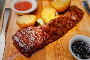 Roast Beef with potatoes and tkemali sauce on a wooden Board