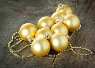 Golden christmas balls on wooden background