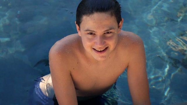 Happy teenage boy diving into pool, super slow motion 120fps
