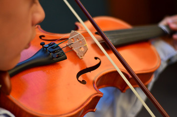 Child playing a violin. Blur style background.