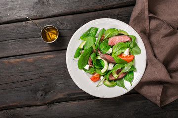 Salad of spinach leaves and grilled beef meat