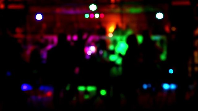 People dancing rock-n-roll at night club, concept blured out of focus silhouette, background live music Elvis Presley - Blue Suede Shoes