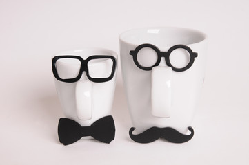 Two coffee cups in mans image. Hipster style, glasses, mustache, bow tie