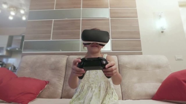 Girl with virtual reality helmet are playing computer console game