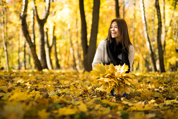 Happy young woman in park on sunny autumn day.