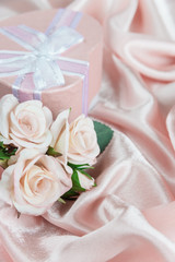 Festive composition with roses and gift box