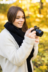 Girl take selfie photo with camera in yellow autumn park