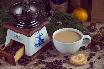 White cup of coffee, coffee grinder, roasted coffee beans, blue