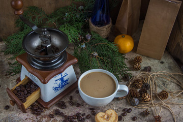 White cup of coffee, coffee grinder, roasted coffee beans, blue
