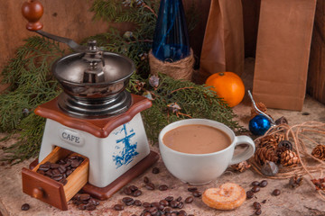 White cup of coffee, coffee grinder, roasted coffee beans, blue