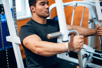 Athlete doing exercise on a simulator in the gym