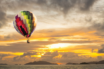 Fototapeta na wymiar Hot air balloon over the sea at Sunset with dramatic sky backgro