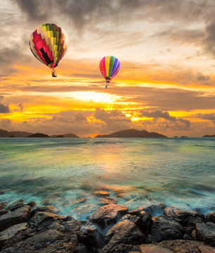 Hot air balloon over the sea at Sunset with dramatic sky backgro
